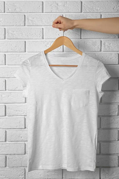 Camiseta blanca en blanco contra pared de ladrillo —  Fotos de Stock