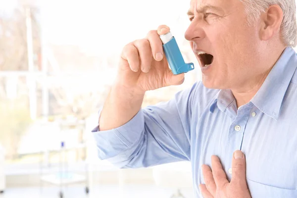 Hombre mayor usando inhalador en la clínica — Foto de Stock