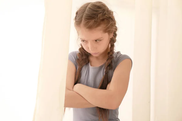 Niña disgustada cerca de la ventana en casa — Foto de Stock