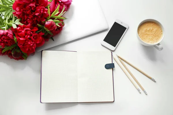 Cuaderno abierto y hermosas peonías fragantes en mesa ligera —  Fotos de Stock