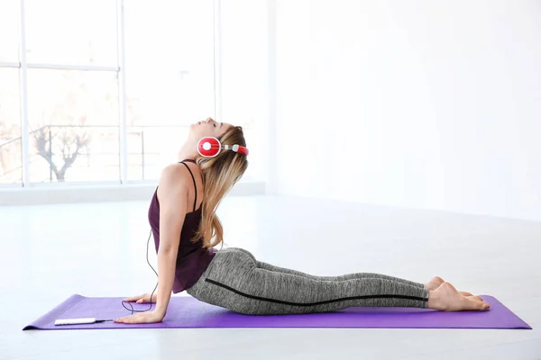 Mulher fazendo ioga e ouvir música — Fotografia de Stock