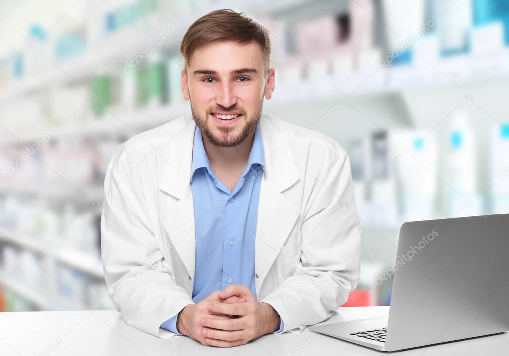 Young male pharmacist near counter  