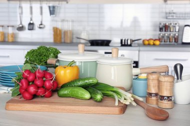 Taze sebze ve ahşap masa üzerinde sınıflar yemek pişirmek için mutfak eşyaları