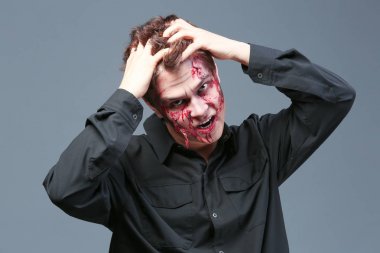 Gri arka plan üzerinde Halloween makyaj ile genç adam