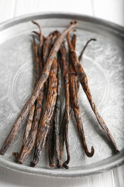 Kurutulmuş vanilya çubukları ile metal plaka