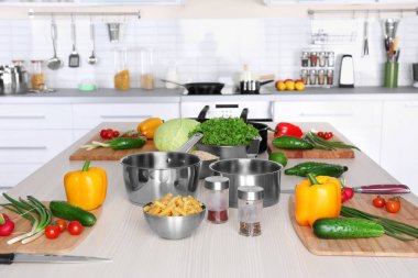 Taze sebze ve ahşap masa üzerinde sınıflar yemek pişirmek için mutfak eşyaları