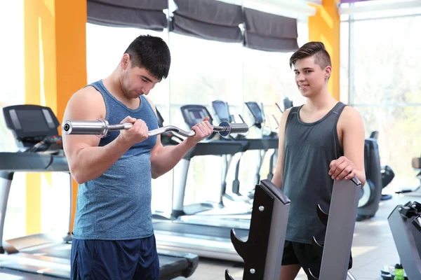 Tata i syn trening ze sztangą w nowoczesnej siłowni — Zdjęcie stockowe