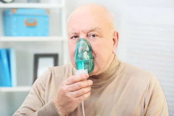 Ανώτερος άνθρωπος χρησιμοποιεί άσθμα μηχάνημα στο σπίτι — Φωτογραφία Αρχείου