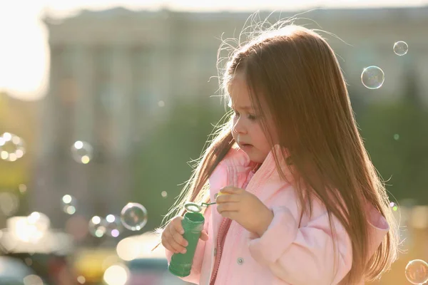 Klein meisje spelen met zeepbellen — Stockfoto