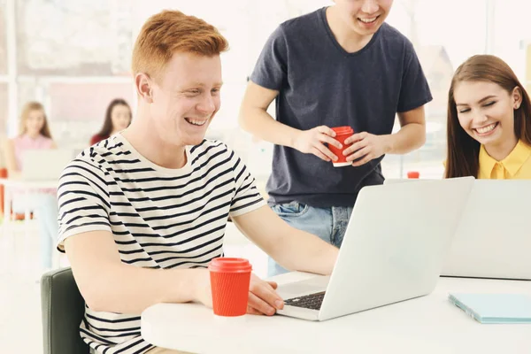 Unga människor som arbetar med bärbara datorer i office — Stockfoto