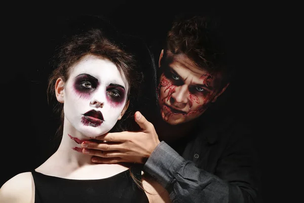 Joven hombre y mujer con maquillaje de Halloween sobre fondo oscuro —  Fotos de Stock