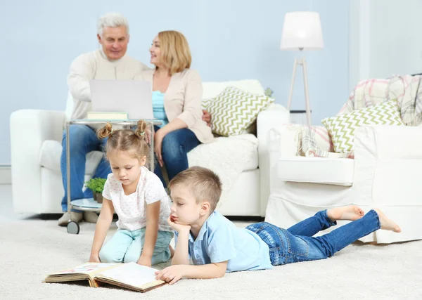 Nietos mirando a través de álbum de fotos en casa — Foto de Stock