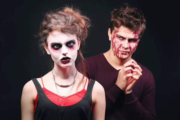 Ung man och kvinna med Halloween smink på mörk bakgrund — Stockfoto