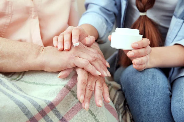 Vnučka pomáhání babičce k ošetření pokožky, zblízka — Stock fotografie