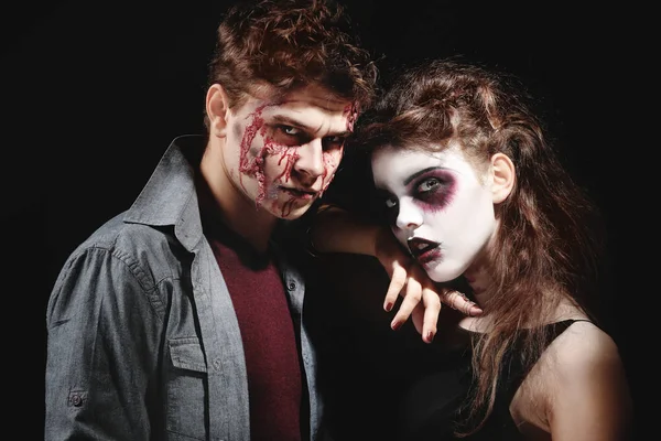 Joven hombre y mujer con maquillaje de Halloween sobre fondo oscuro —  Fotos de Stock