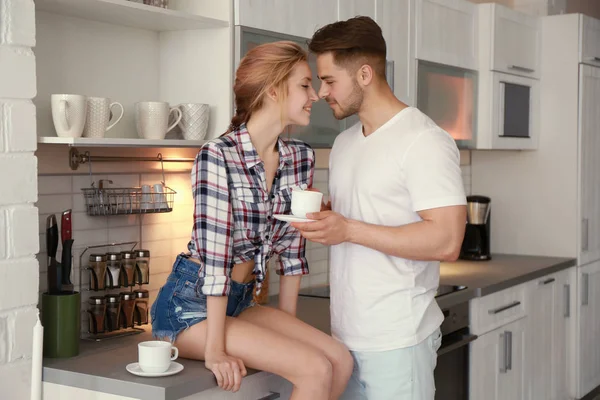 Morning of happy young couple drinking tea in kitchen — Stock Photo, Image