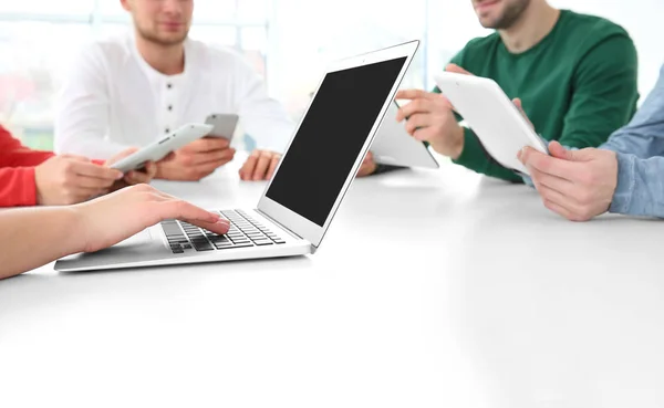 Concepto de trabajo en equipo. Personas sentadas a la mesa en la oficina y utilizando dispositivos digitales —  Fotos de Stock