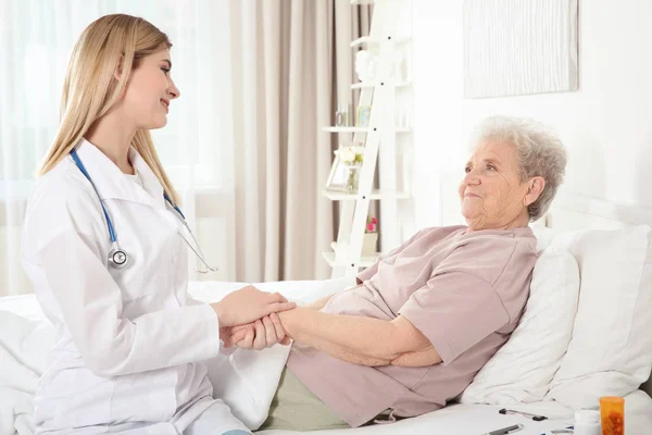 Nurse examining elderly woman — Stock Photo, Image