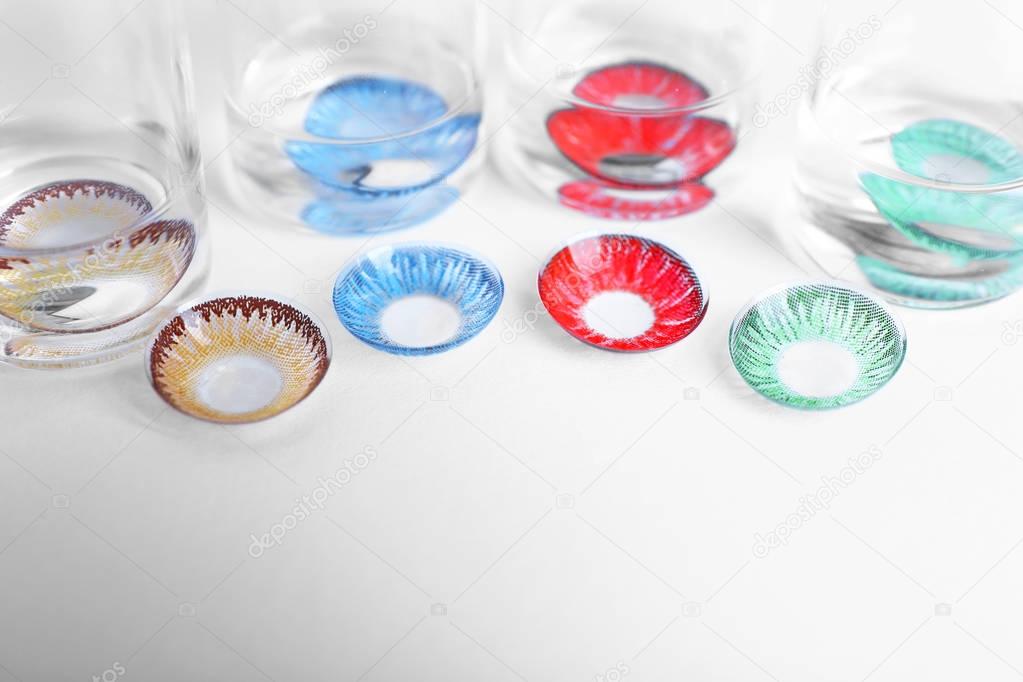 Color contact lenses and glass bottles on white background