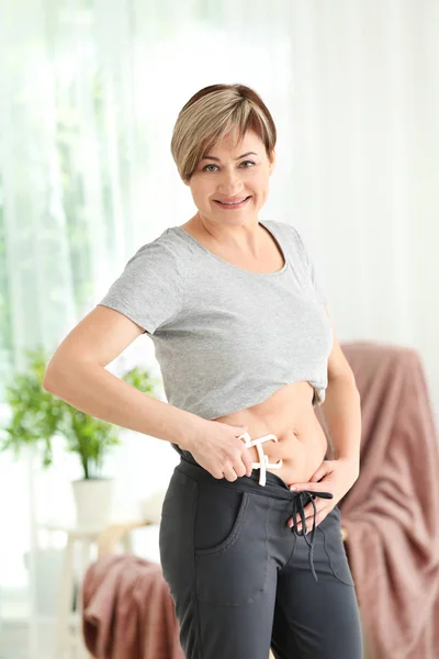 Mature woman with measuring caliper — Stock Photo, Image