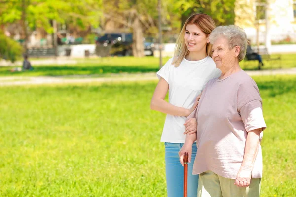 Mujer anciana y cuidador joven — Foto de Stock