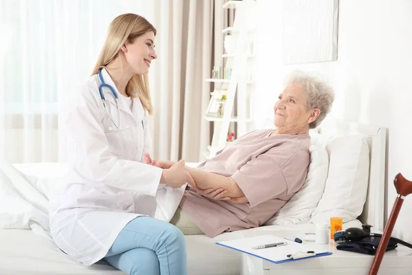 Nurse examining elderly woman — Stock Photo, Image