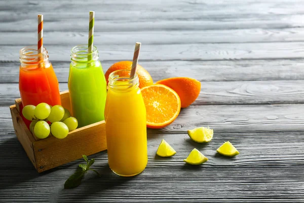 Flaskor med utsökt juice med råvaror — Stockfoto