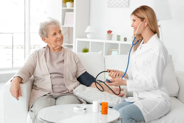 Nurse measuring blood pressure — Stock Photo, Image