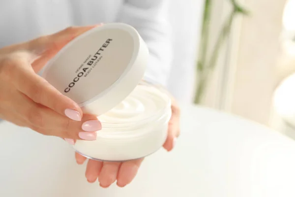 Frau hält Glas mit Kakaobutter-Lotion — Stockfoto