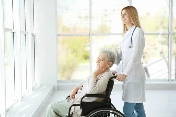 Verpleegkundige en gehandicapte bejaarde vrouw — Stockfoto