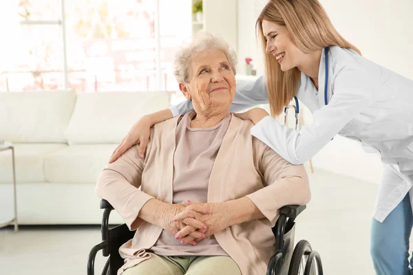 Verpleegkundige en gehandicapte bejaarde vrouw — Stockfoto