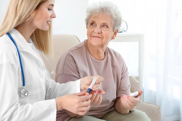 Infermiera esaminando donna anziana — Foto Stock