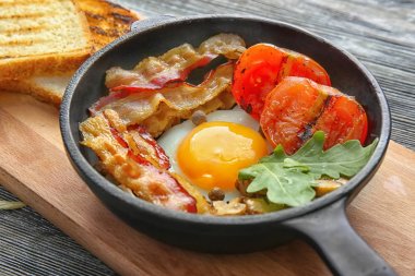 Kızartma tavası lezzetli yumurta, pastırma ve domates ile