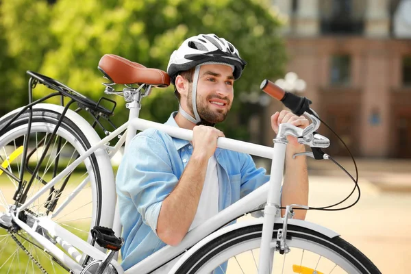 Jovem carregando bicicleta — Fotografia de Stock