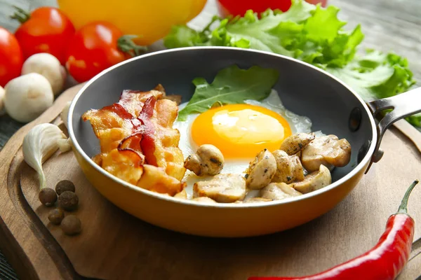 Kızartma tavası lezzetli yumurta, pastırma ve mantar ile — Stok fotoğraf