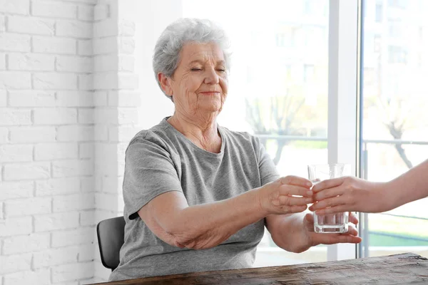 Pohár vizet adva az idős asszony — Stock Fotó