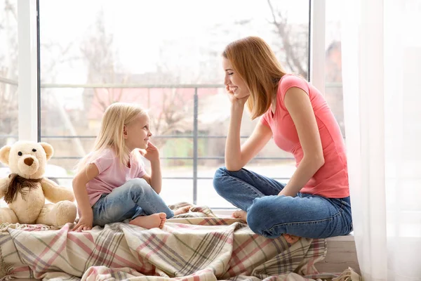 Mother and daughter on windowsill — Stock Photo, Image