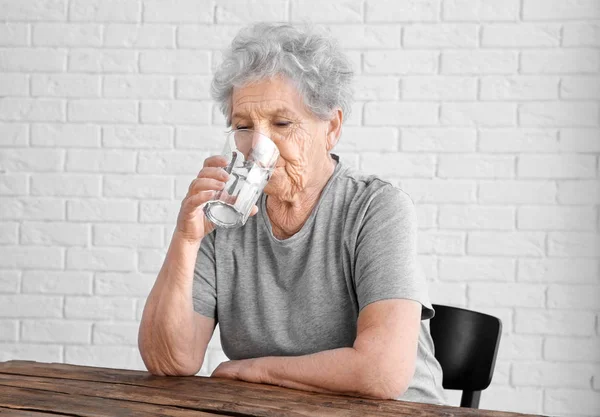 高齢者の女性は、水を飲む — ストック写真