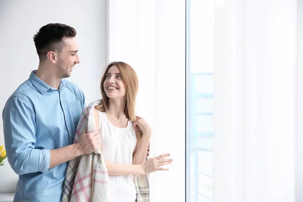 Couple standing near window — Stock Photo, Image