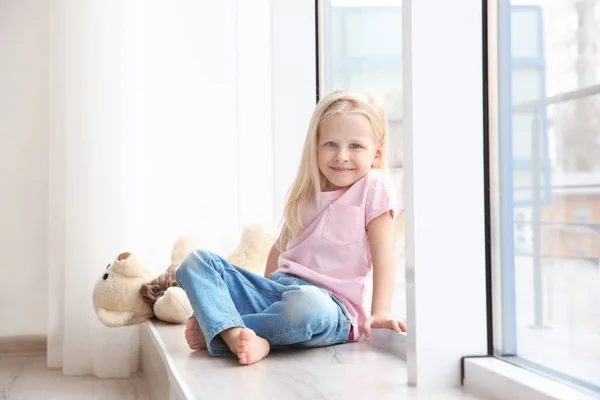 Girl sitting on windowsill — Stock Photo, Image