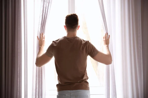 Man opening curtains — Stock Photo, Image