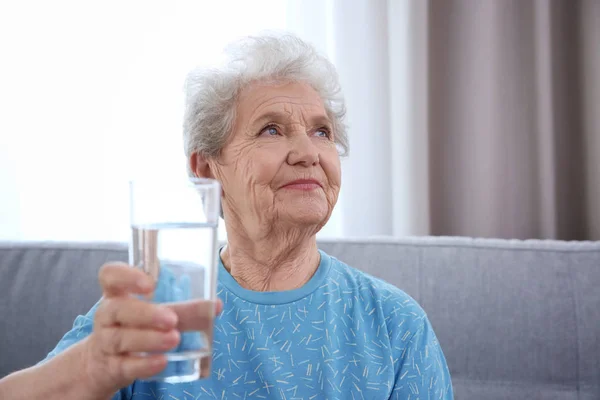 Anciana sosteniendo vaso de agua — Foto de Stock