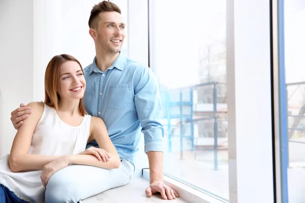 Lyckliga paret sitter på fönsterbräda — Stockfoto