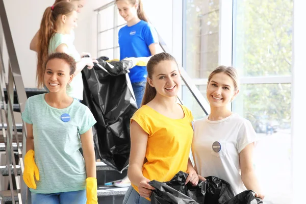 Çöp torbaları üzerinde merdiven pencere yakınındaki ile genç Gönüllüleri ekibi — Stok fotoğraf