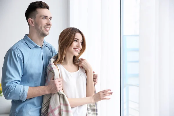 Pareja de pie cerca de ventana — Foto de Stock