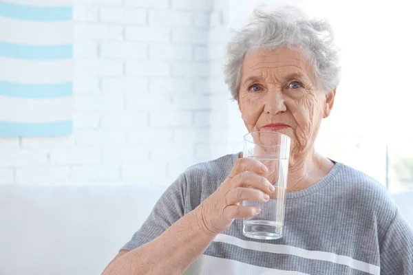 水のガラスを保持している高齢者の女性 — ストック写真