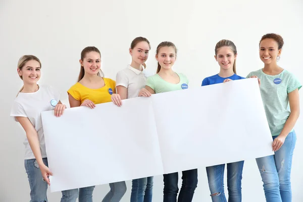 Jovens voluntários com cartaz sobre fundo branco — Fotografia de Stock