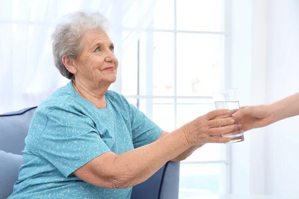 Pohár vizet adva az idős asszony — Stock Fotó