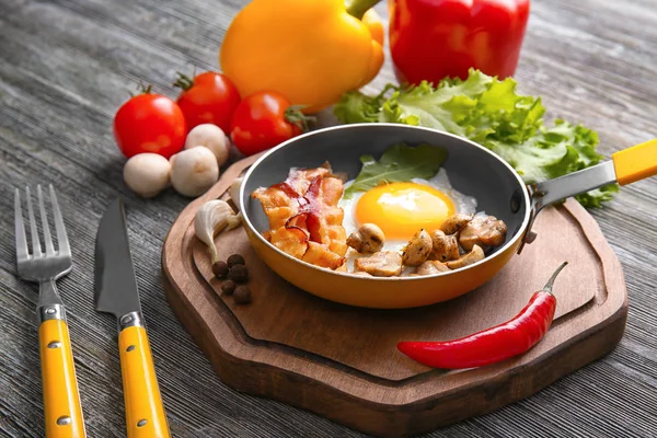 Сковородка с вкусным яйцом, беконом и грибами — стоковое фото