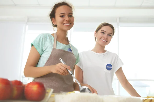 Volunteers near table with different products — Stock Photo, Image